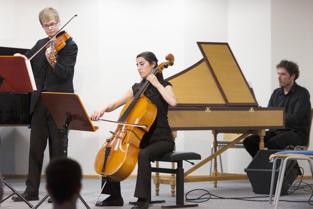 Drei Studierende musizieren.