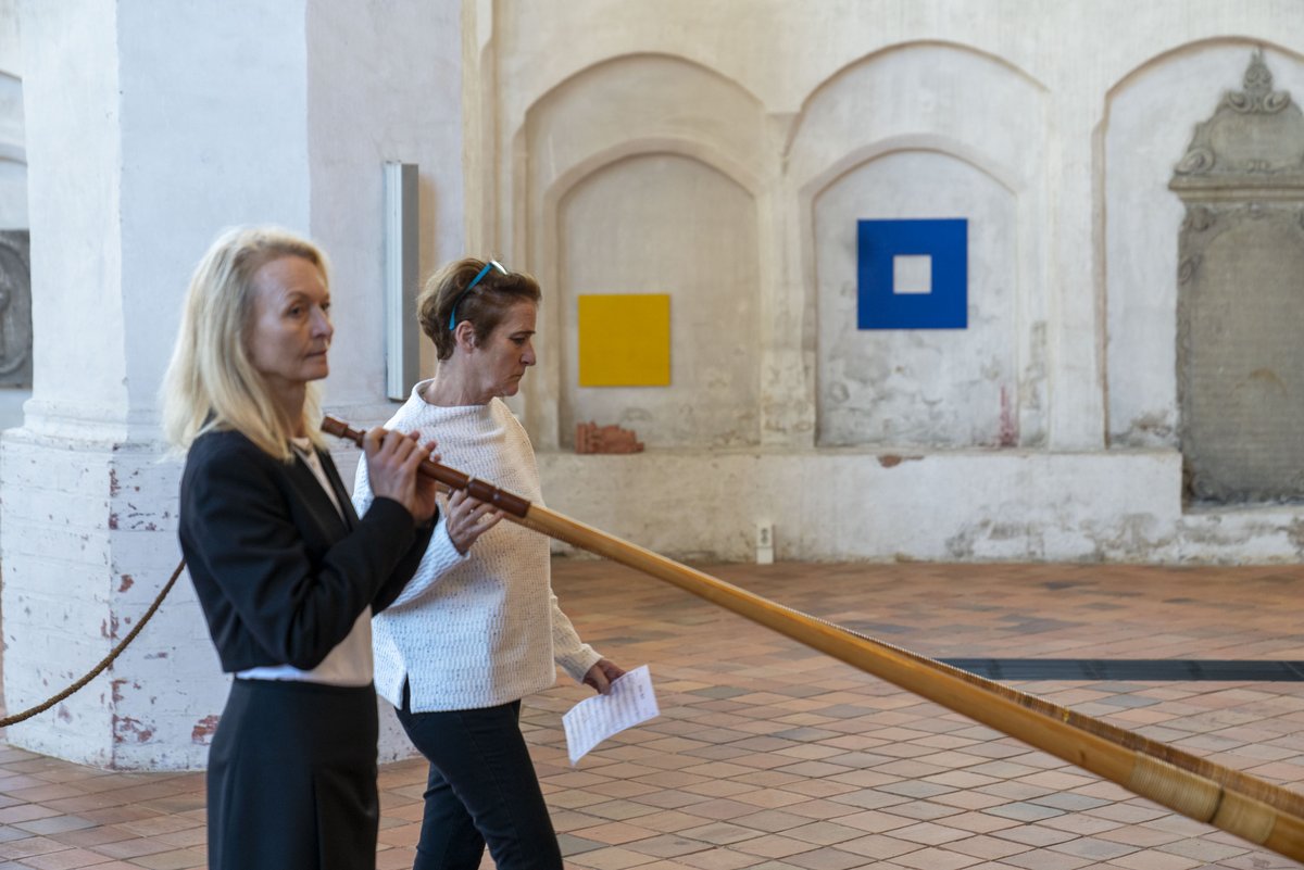 Musikerinnen mit Alphörnern, im Hintergrund Kunstobjekte in den Nischen des Kirchenraumes