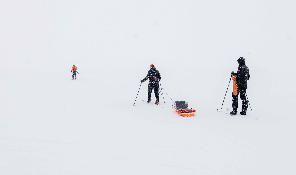 Nothing but ice, and two people walking with a sledge 
