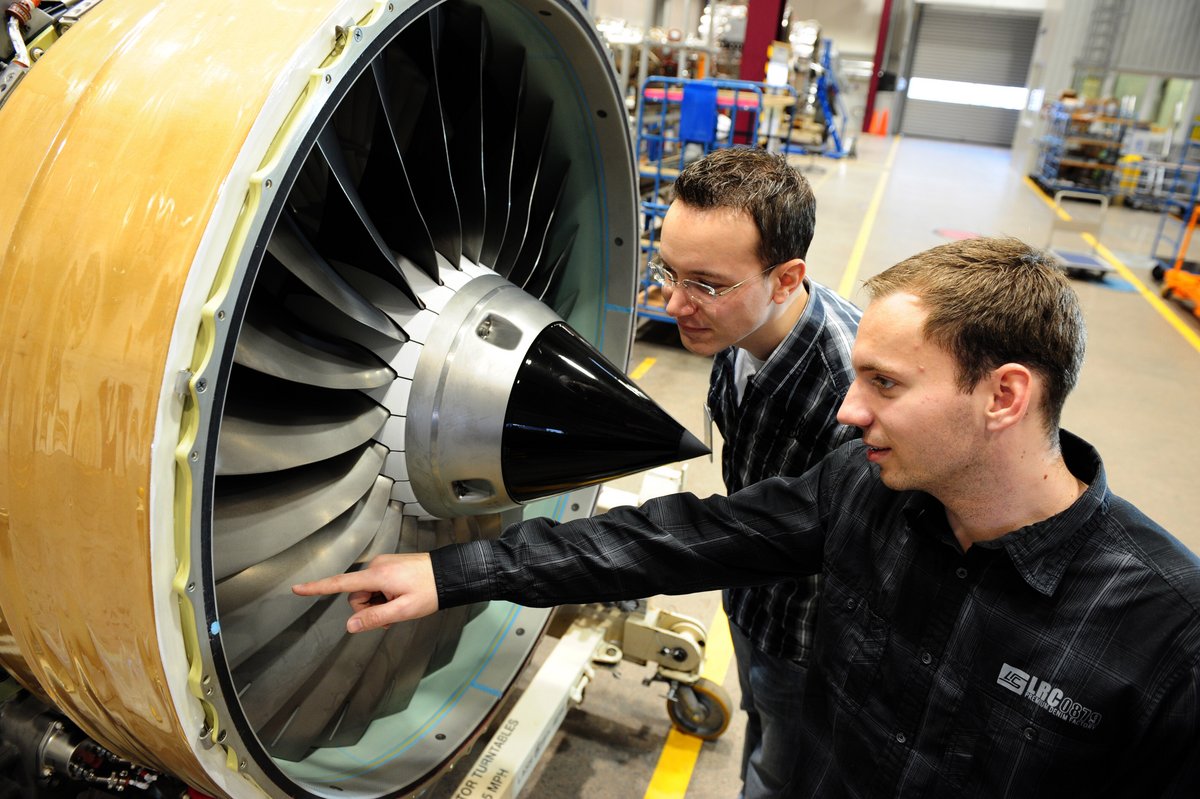 Studierende des Maschinenbaus mit Schwerpunkt Triebwerkstechnik untersuchen eine Flugzeugturbine.