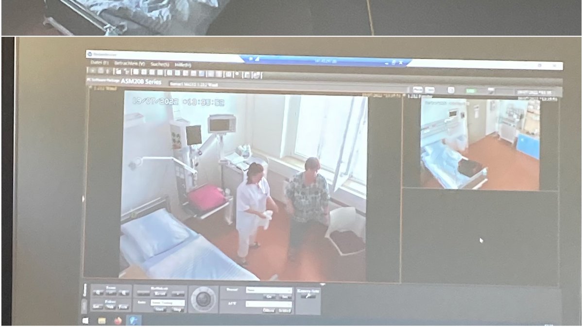 Das Bild zeigt eine Videoübertragung in ein Patient*innenzimmer, wo eine Simualtionspatient*in und eine Pflegestudierende eine Pflegesituation nachspielen.