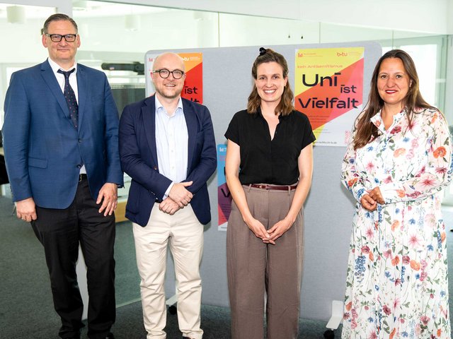 Gruppenbild vor den Plakaten "Uni ist Vielfalt"