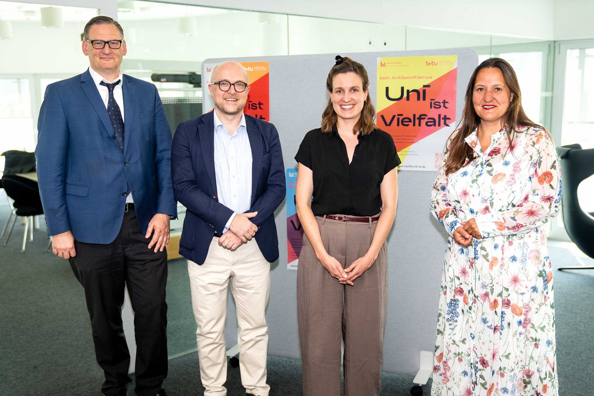 Gruppenbild vor den Plakaten "Uni ist Vielfalt"