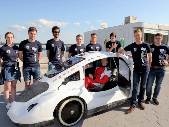 Gruppenfoto des studentischen Teams Lausitz Dynamics mit seienm Energiesparmobil Lupus - aufgenommen an Senftenberger Stadthafen. 