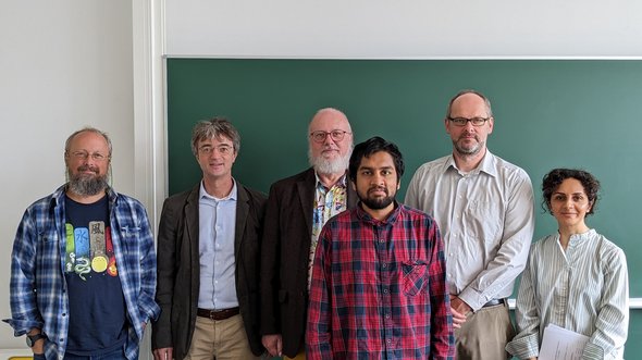 (v.l.n.r.) Douglas W. Cunningham, Michael Oevermann, Martin Welk, Vivek Sridhar, Miochael Breuß und Shima Shabani. 5 Personen stehen vor einer Tafel.