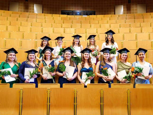 Die ersten Absolventinnen des Studiengangs Hebammenwissenschaft der BTU stehen im Hörsaal.