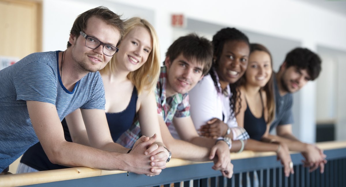 Das Banner von der "Start up your Career in Germany Seite" - Auf dem Bild stehen sechs Studierende in einem Lehrgebäude der BTU
