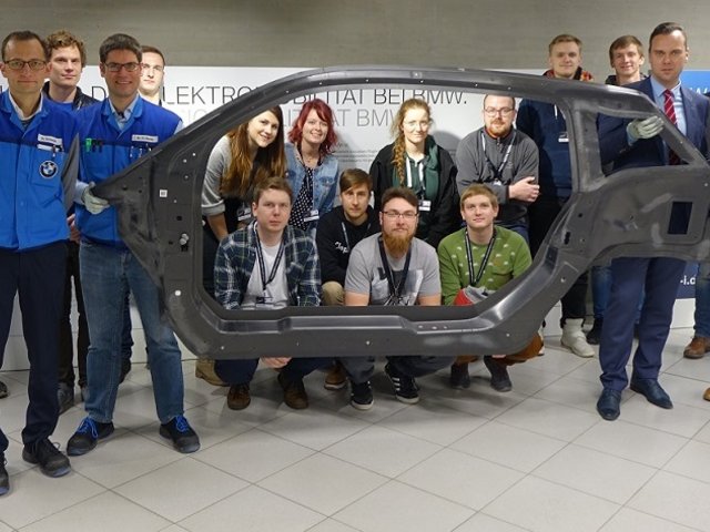 Prof. Seidlitz, BMW Mitarbeiter und Studenten gruppieren sich um BMW i3 Seitenrahmen
