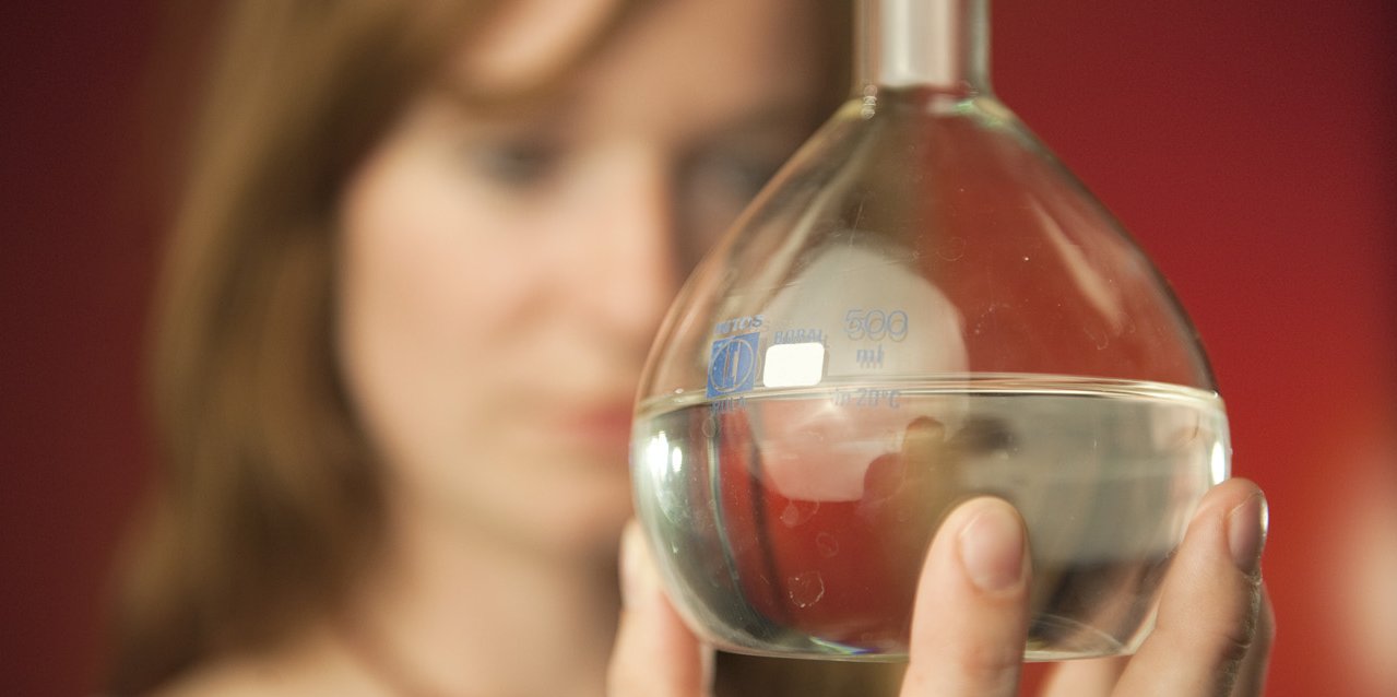 Student in the Master of Process and Plant Engineering holds volumetric flask in her hand