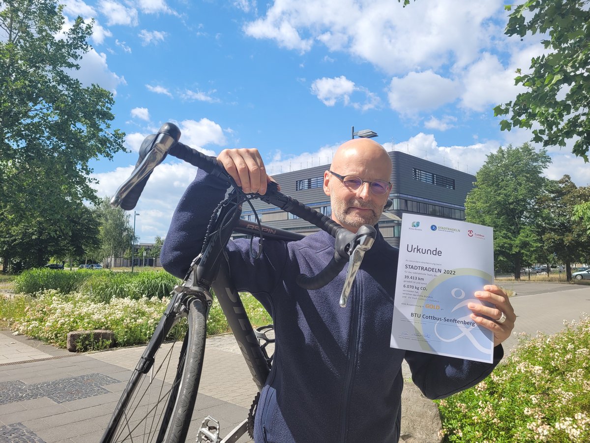 Vizepräsident mit dem Rad über der Schulter am Zentralcampus