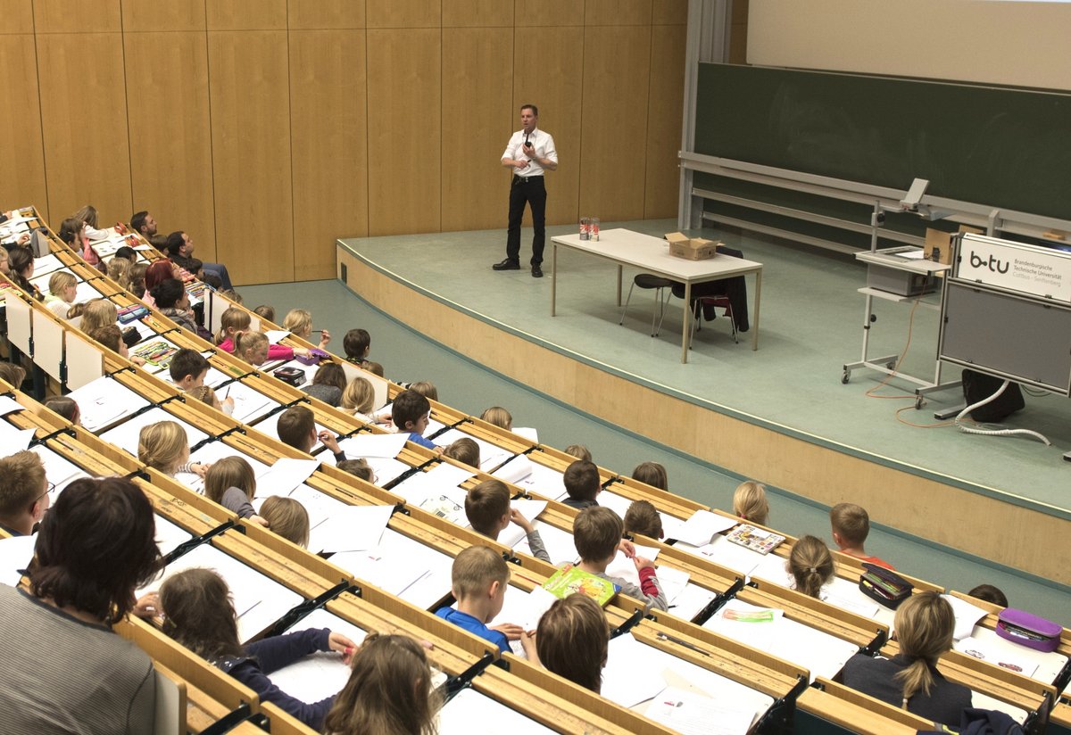Schülerinnen und Schüler in einer Kinderuni-Vorlesung an der BTU Cottbus-Senftenberg im Hörsaal sitzend.