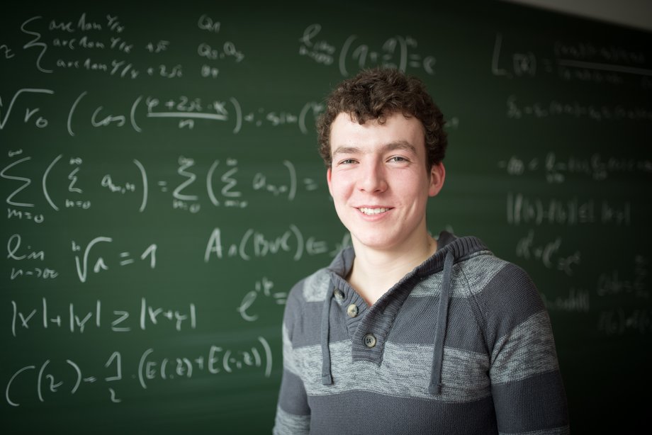 Mathematik Student Niklas Füller vor eine Tafel mit mathematischen Formeln