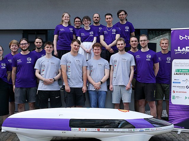 Das studentische Team Lausitz Dynamics der BTU, hinter und neben seinem Energiesparmobil HydroRaycer stehend.
