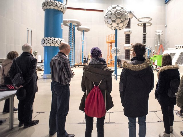 Teilnehmende am Zukunftstag 2019 stehen in der Hochspannungshalle am Zentralcampus Cottbus und folgen den Erläuterungen eines Wissenschaftlers.