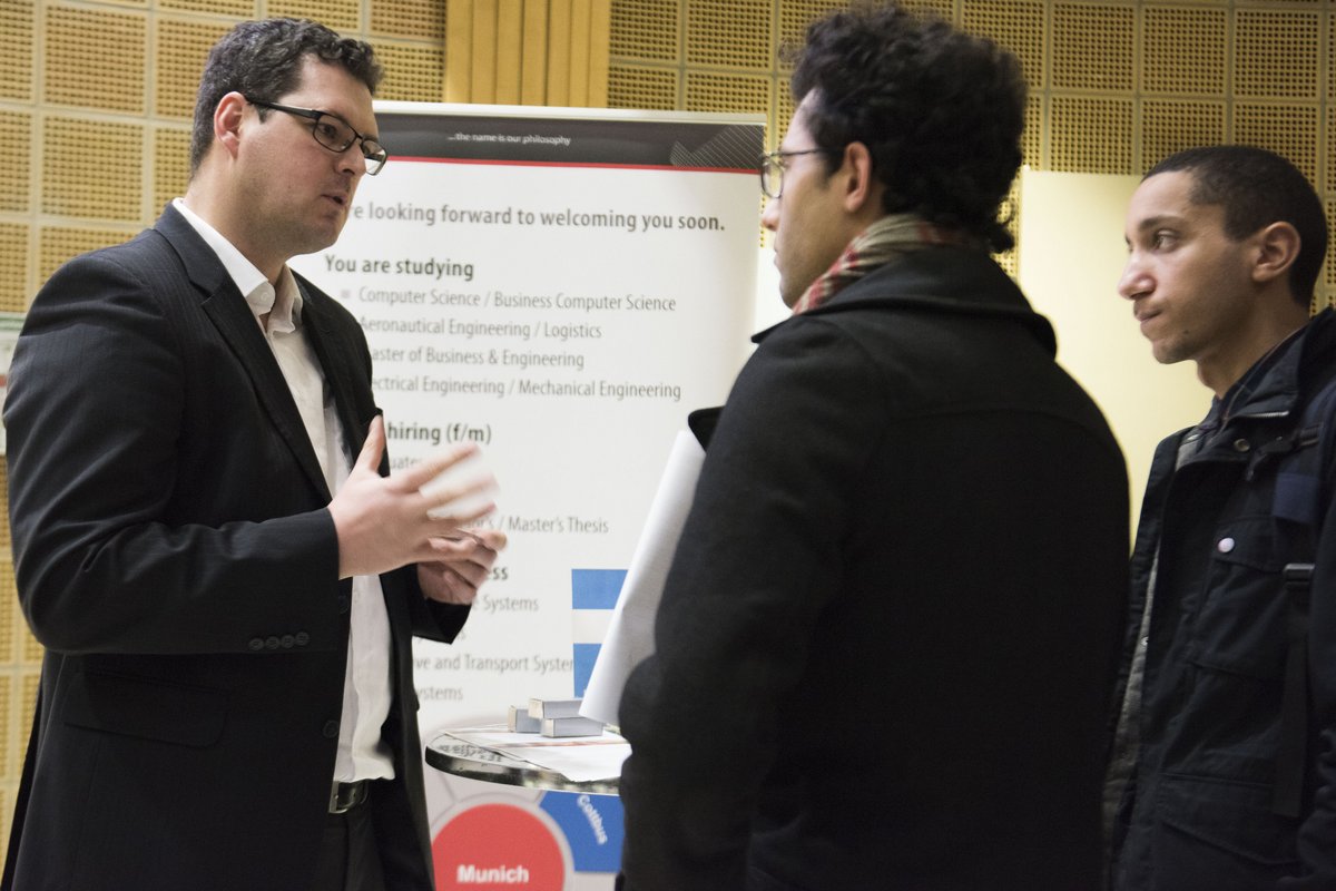 Unternehmensvertreter und Student am Stand der Philotech GmbH.