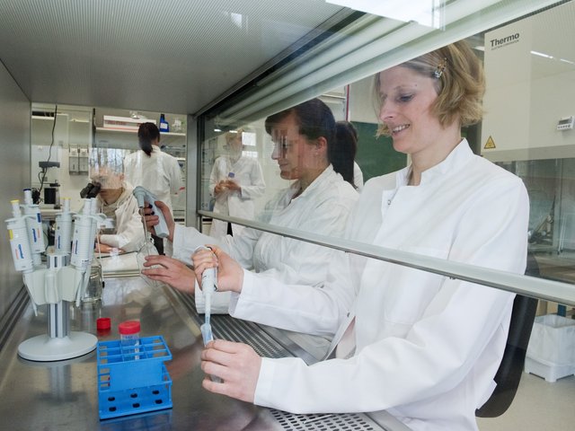 Eine Mitarbeiterin und eine Studentin beim Pipettieren im eienm Biotechnologielabor.
