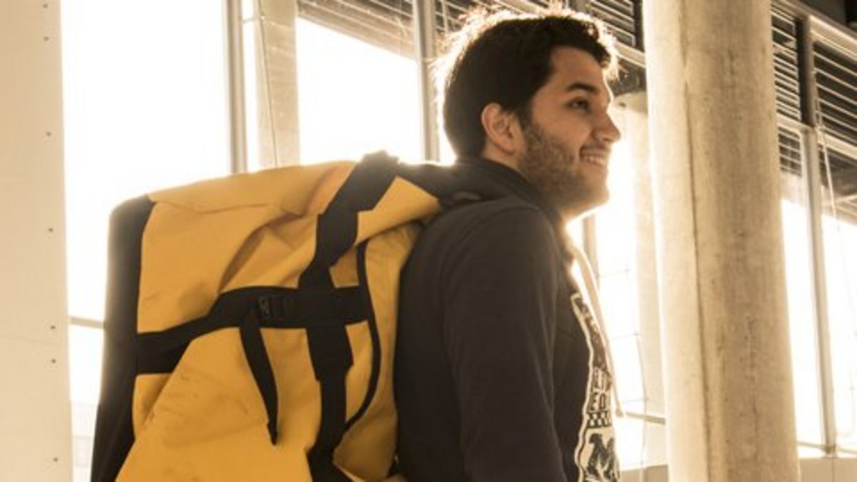 Das Banner von der Studierende ins Ausland Seite - Auf dem Bild steht ein Student mit einem Rucksack in einem BTU-Gebäude