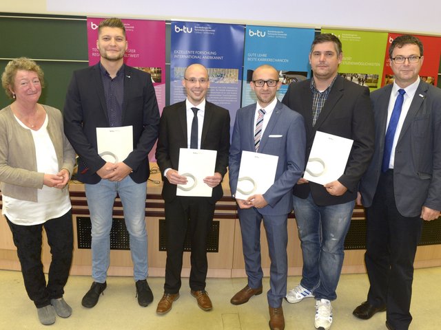 Herausragende Masterabsolventen des Maschinenbaus aus dem Jahr 2017 präsentieren, neben Prof. Dr. Kathrin Lehmann (li.) und Prof. Dr. Sylvio Simon (re.) stehend, ihre Zeugnisse.