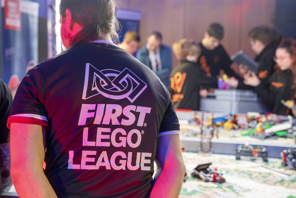 in the foreground: young man with a T-shirt from the First Lego League st6