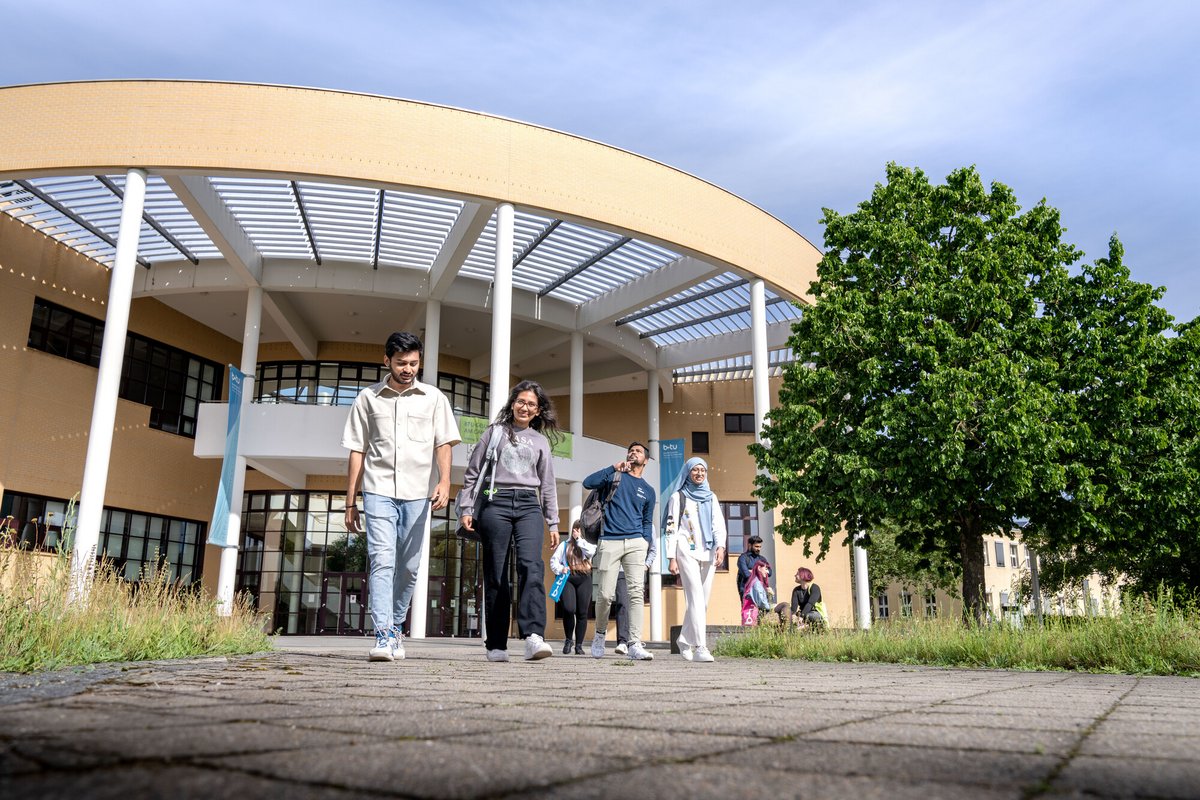 Studierende laufen über den Campus 