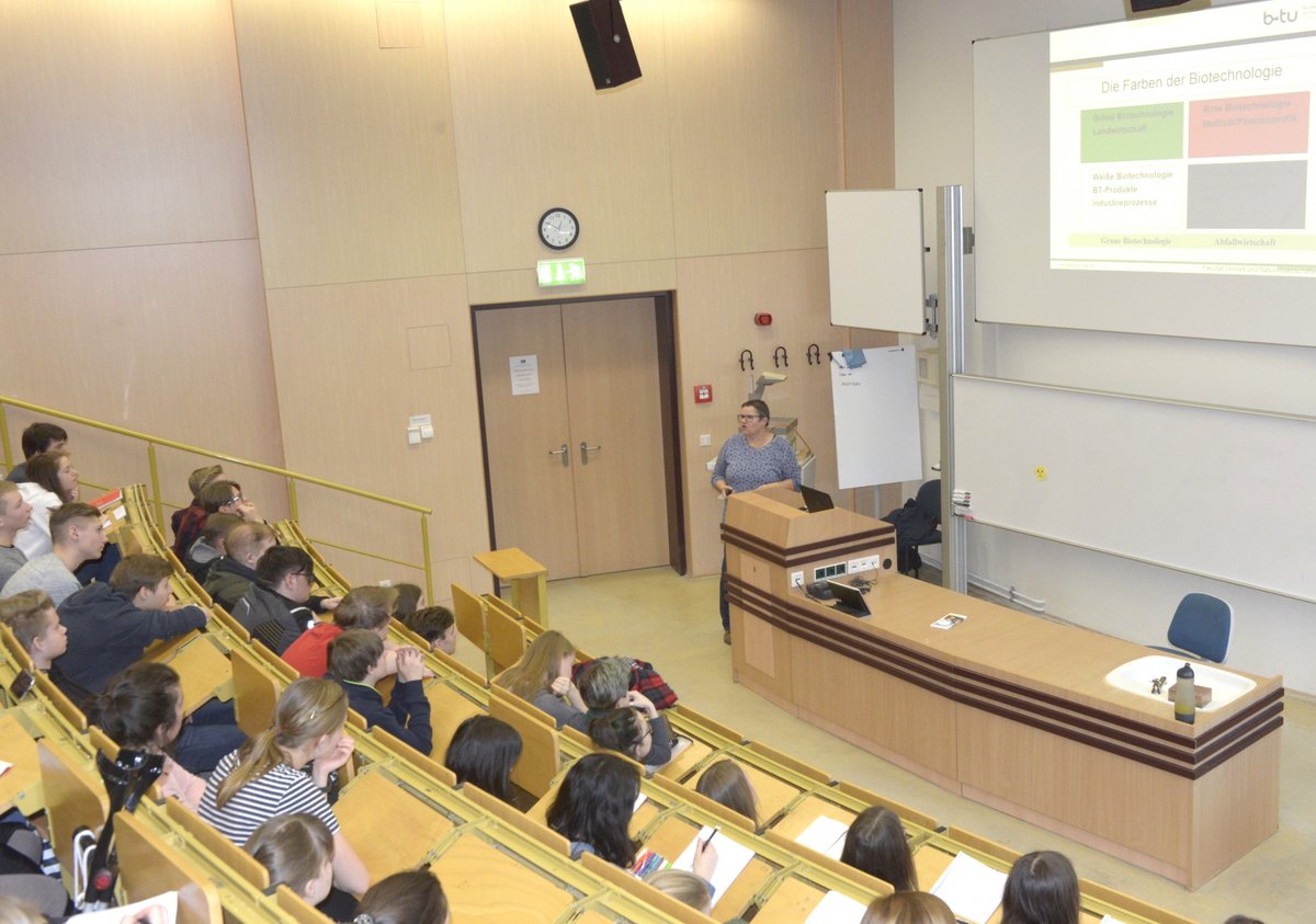 Schülerinnen und Schüler folgen, im Hörsaal sitzend, dem Abschlussvortrag von Dr. Barbara Hansen.