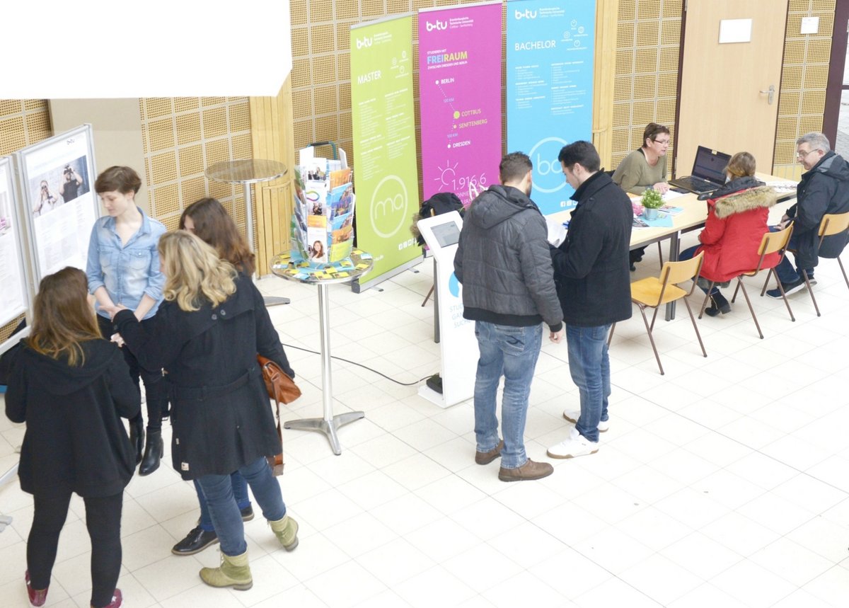 Studieninteressierte werden an Informationsständen im Foyer des Konrad-Zuse-Medienzentrums von Mitarbeitern und Studierenden beraten.