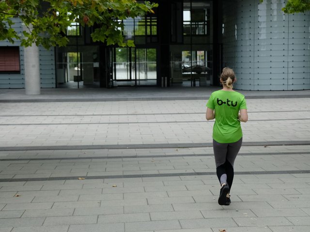 Teilnehmerin am Firmenlauf vor dem Hauptgebäude der BTU