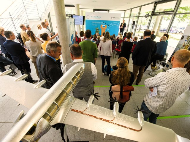 Participants of the 7th BTU Transfer Day 2022 at a lecture, in the foreground an airplane model.