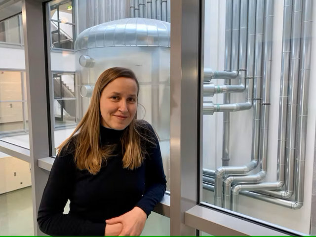 Dr. Christin Hoffmann vor dem Wärmespeicher der Wärmepumpe im Uni-Gebäude