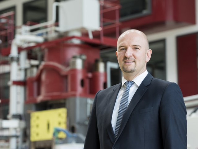 Prof. Markus Bambach vor einer Presse in der Halle des Panta Rhei Zentrums für Leichtbauforschung