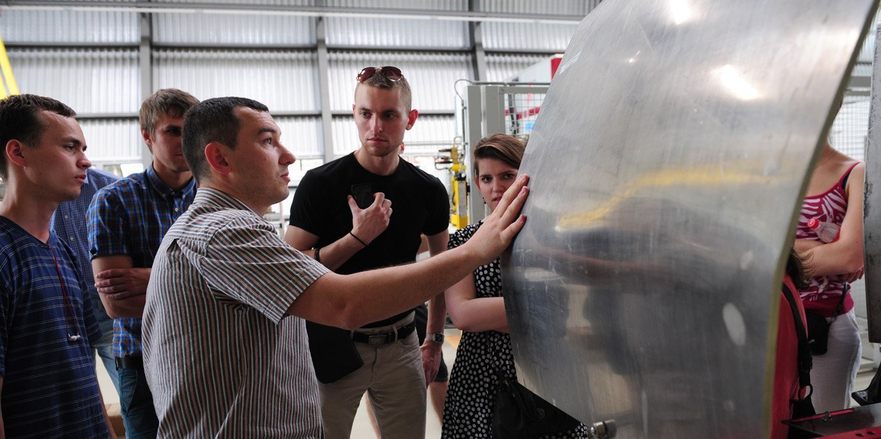 A group of students in the bachelor's programme in mechanical engineering examines a workpiece together with the lecturer