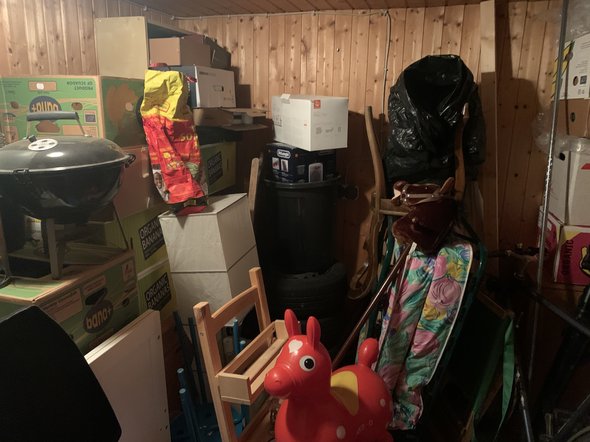 A cellar room with toys, shelves, old furniture etc.
