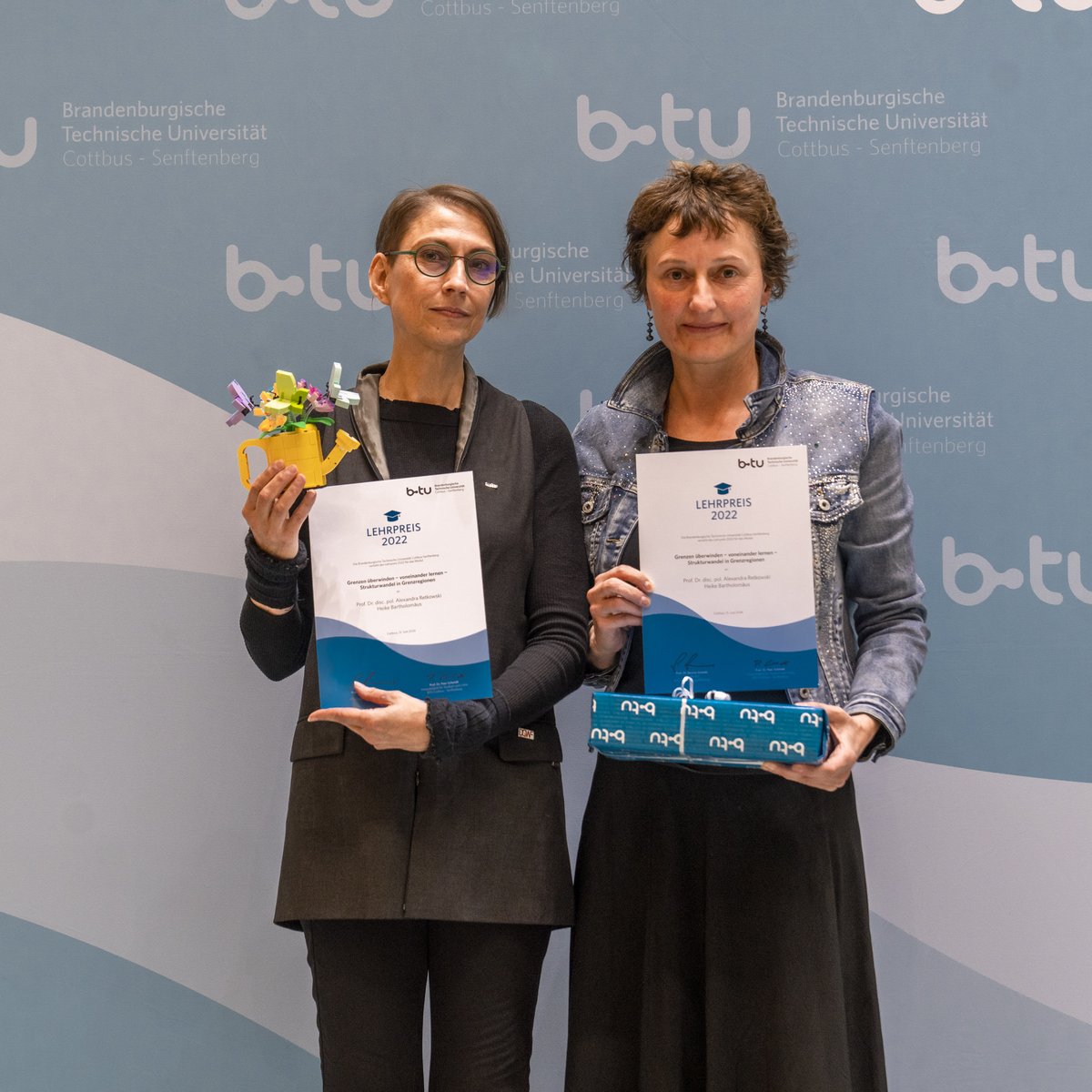 Zwei Frauen halten Urkunden hoch