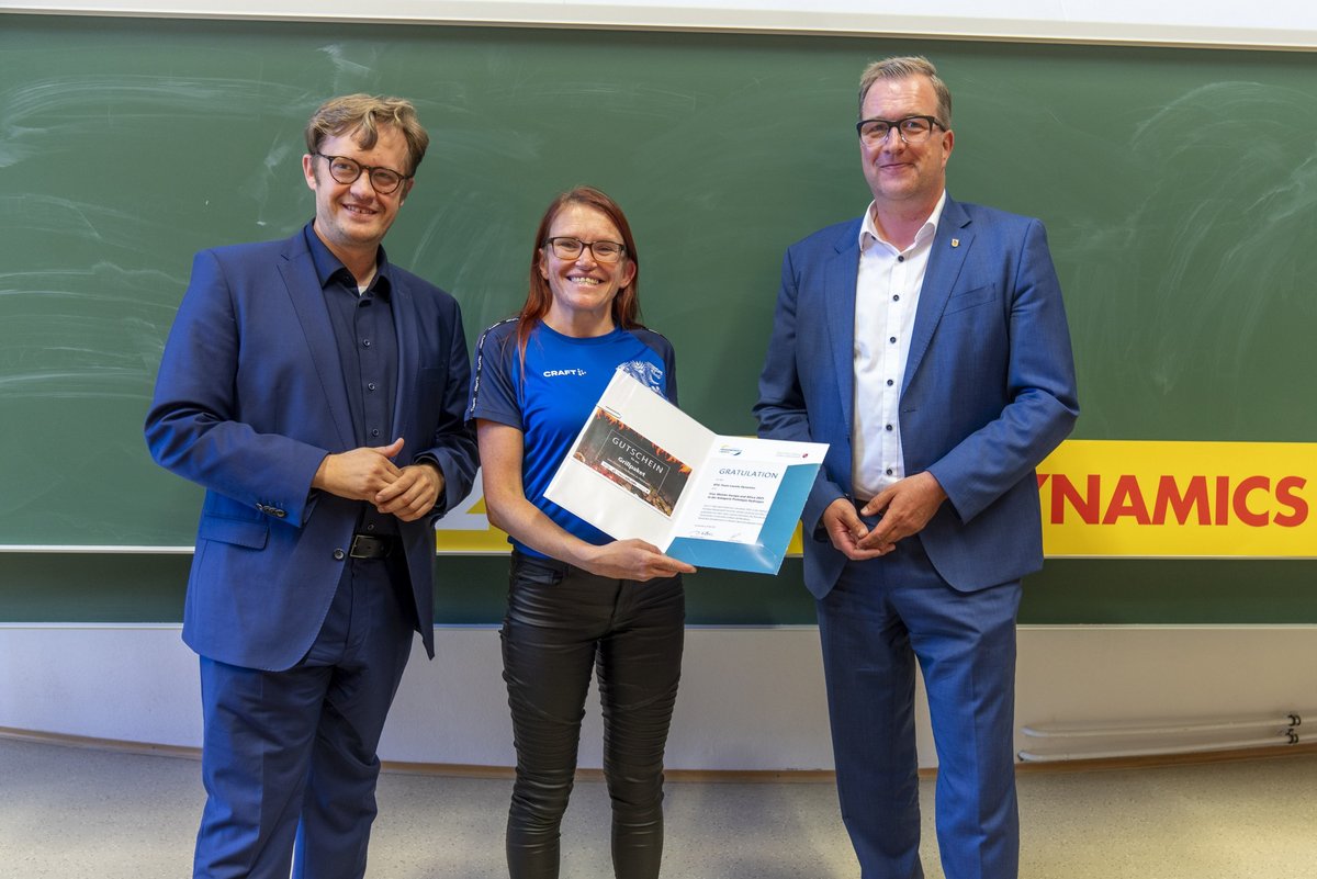 Der Bürgermeister der Stadt Senftenberg Andreas Pfeiffer (links) und der Bildungsdezernet des Landkreises Oberspreewald-Lausitz (rexhts) danken dem Team Lauistz Dynamics, vetreten durch die fachliche Betreuerein Sindy Schmidt (Mitte) mit einem Gutschein..