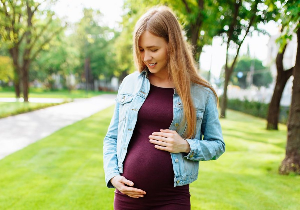 Schwangere junge Frau im Park