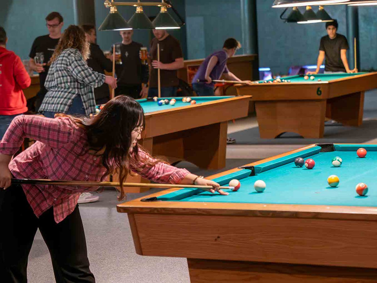 Student plays billiards 