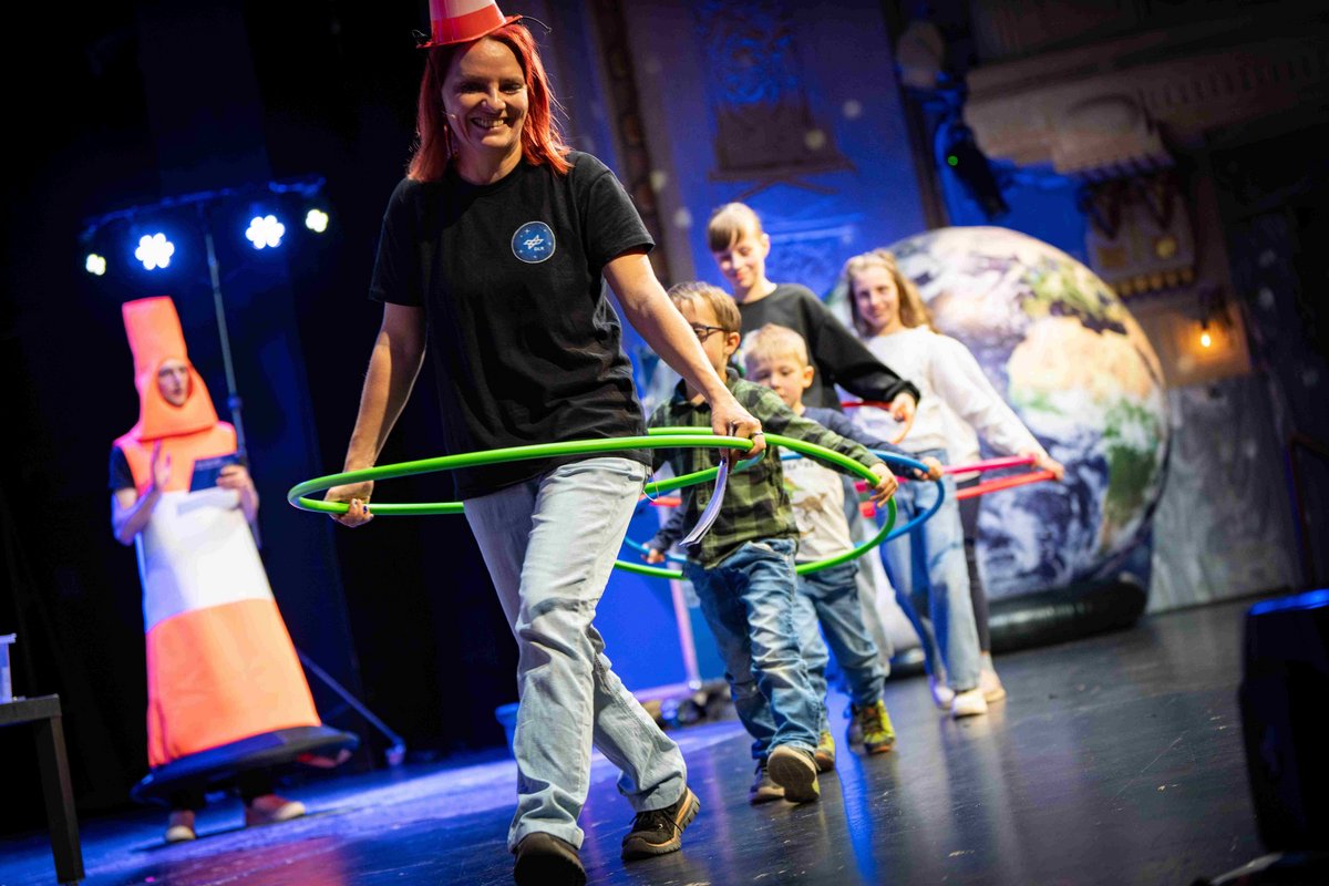 KInder mit der Moderatorin auf der Bühne.