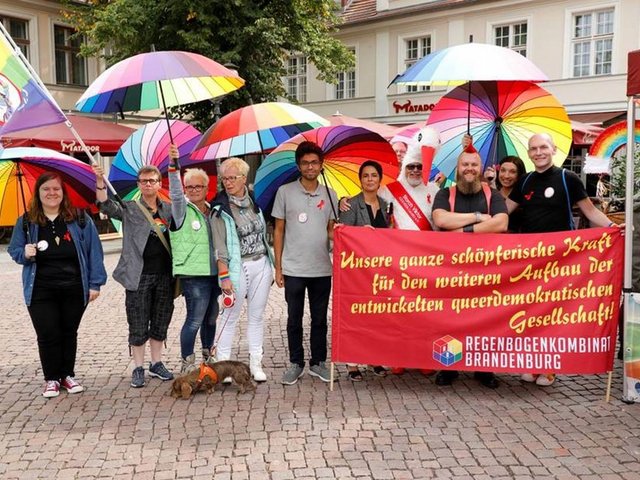 Menschengruppe mit bunten Schirmen