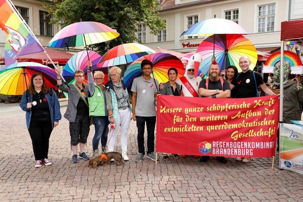 Menschengruppe mit bunten Schirmen