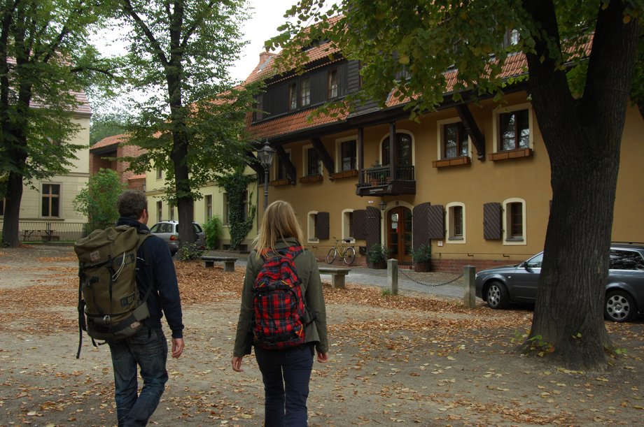 Auf dem Bild stehen zwei Studierende mit Rucksäcke