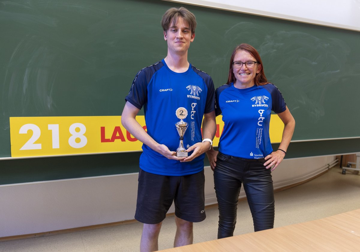 Der studentische Team-Manager Theo Beutke und Betreuerin Sindy Schmidt mit einem kleinen Pokal.