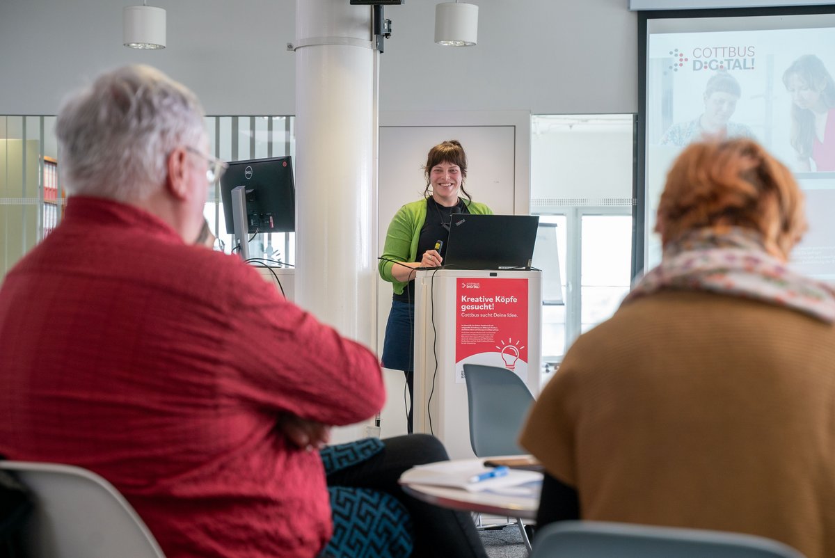 Referintin und Teilnehmende eines Vortrags