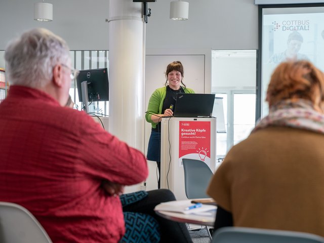 Referintin und Teilnehmende eines Vortrags