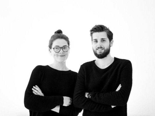 Architektur Absolventen Maria Constanze Hutter und Marc Timo Berg in schwarzer Kleidung vor weißem Hintergrund