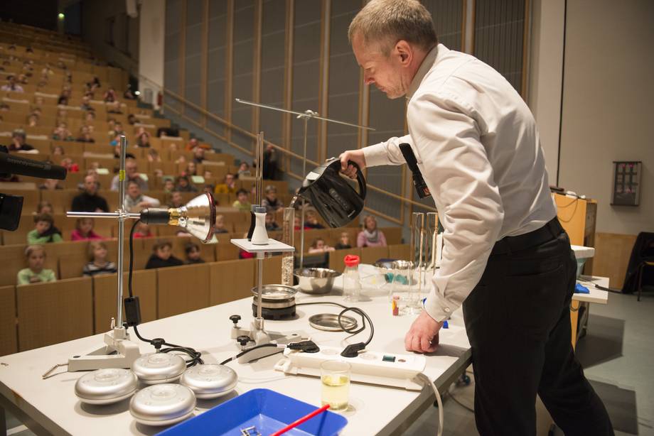 Kinder-Uni Kinder im Hörsaal beobachten den Professor beim Experiment