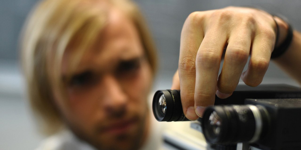 Student adjusts a camera in the study program information and media technology