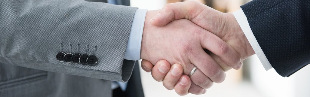 Händedruck Handschütteln von 2 Personen im Anzug, wobei nur die Hände und ein teil des Arms sichtbar sind.