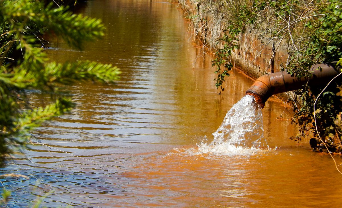 Rohrleitung spült schmutziges Wasser in den Fluß