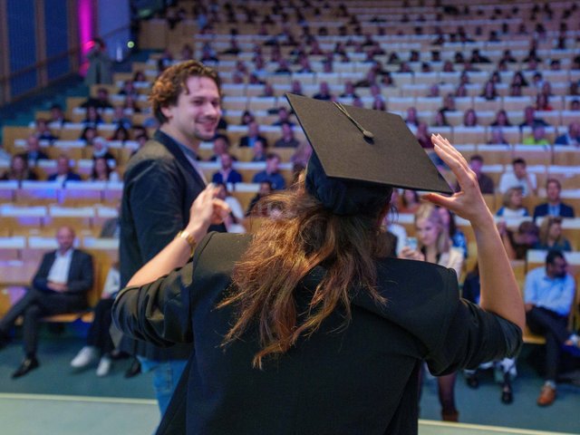 Young woman with doctor's hat in front of the auditorium