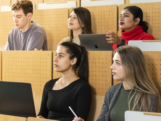 Students sit in the lecture hall.